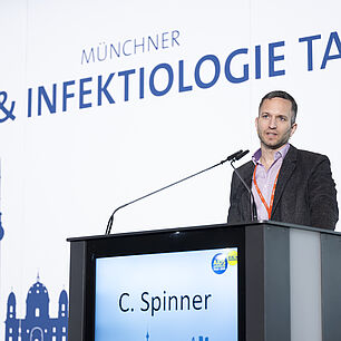 Dr. Spinner auf der Bühne während seines Vortrags bei den 20. Münchner AIDS- und Infektiologie-Tagen 2026 in Berlin
